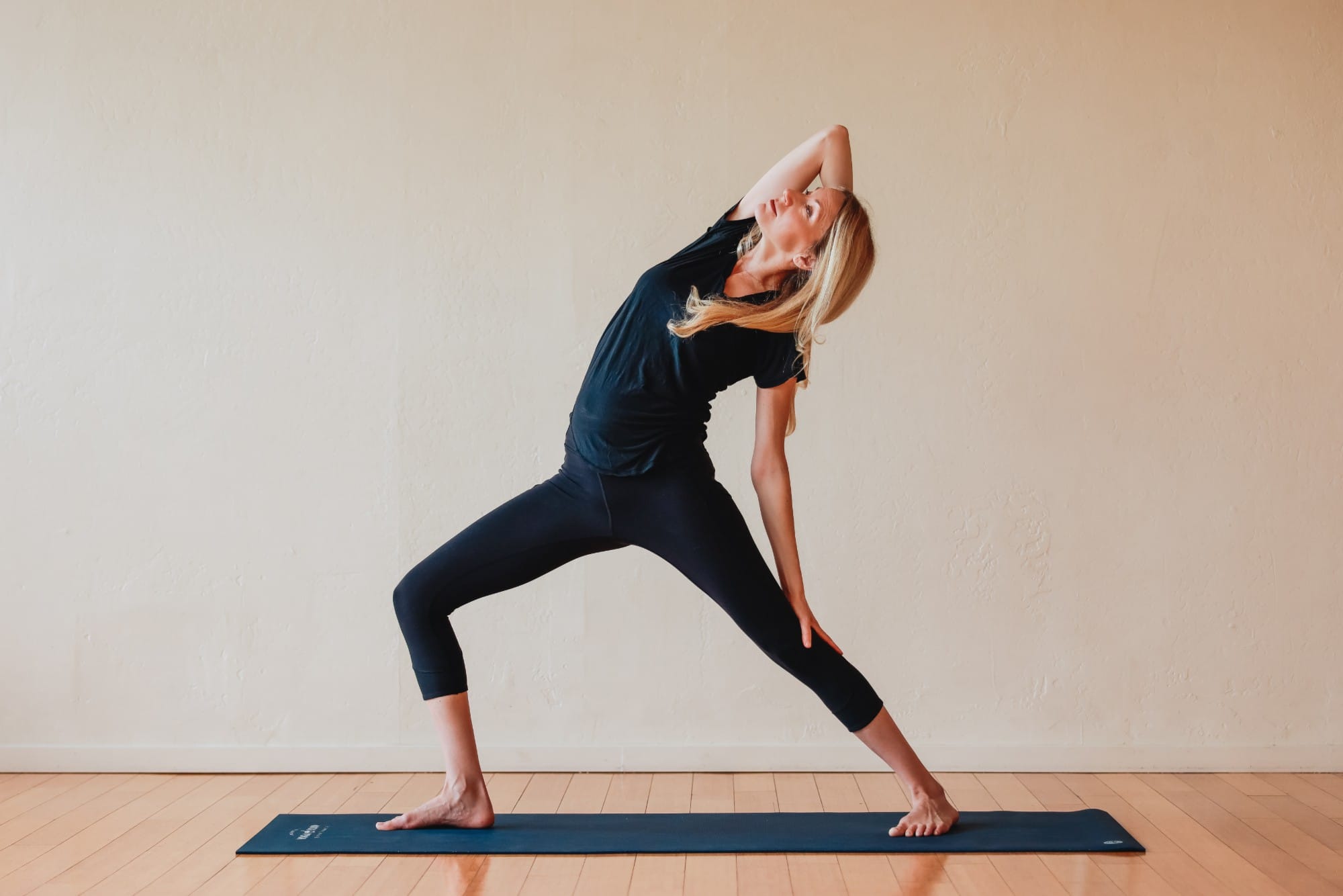 Kara in reverse warrior pose, one arm over her head